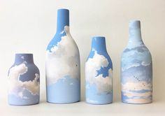 three blue and white vases with clouds painted on the bottles next to each other