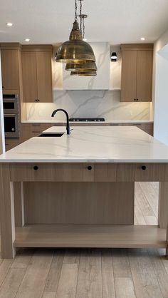 a large kitchen island with two lights hanging from it's ceiling and an oven in the background