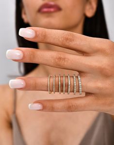 a woman's hand with five rings on her finger and one ring in the middle