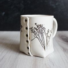 a white coffee cup sitting on top of a wooden table