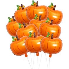 a bunch of orange pumpkins are in the air with green leaves on each balloon