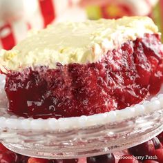 a close up of a piece of cake on a plate with berries in the background