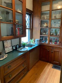 a kitchen with wooden cabinets and green counter tops on top of a hard wood floor