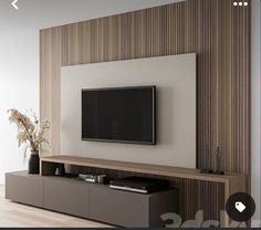 a flat screen tv mounted to the side of a wall in front of a wooden entertainment center