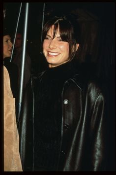 a smiling woman wearing a black leather jacket