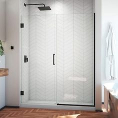 a bathroom with a walk in shower next to a bathtub and wooden flooring