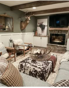 a living room filled with furniture and a deer head mounted on the wall above it