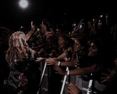 a group of people standing next to each other in front of a crowd holding up their hands