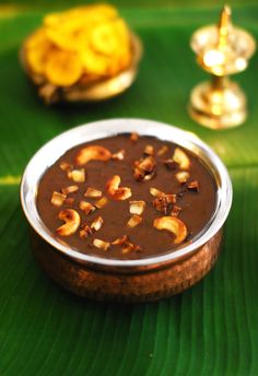 a bowl filled with chocolate and nuts on top of a green leaf covered tablecloth