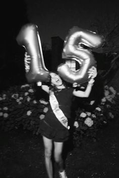 a woman is holding two large balloons in the shape of the number five and an eight