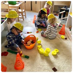 children playing with construction hats on the floor