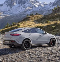 the mercedes benz suv is parked in front of some mountains