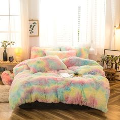 a bed room with a neatly made bed covered in colorful comforter and pillows on top of it