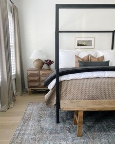 a bedroom with a four poster bed and rug