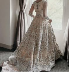 a woman standing in front of a window wearing a dress with sequins on it