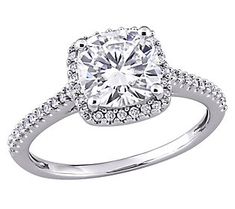 a white gold engagement ring with diamonds on the band and an oval center stone surrounded by round