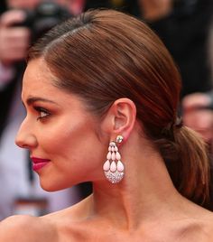 a woman with long hair and earrings on top of her head