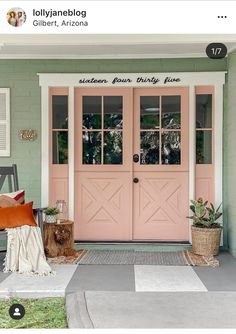 a pink front door with two windows