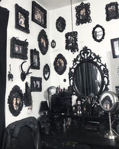 a room with black and white pictures on the wall, mirrors and other items hanging on the wall