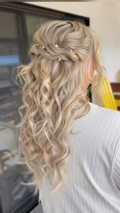 a woman with long blonde hair in a half - up hairstyle, looking out the window