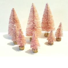 small pink trees are lined up on a white surface