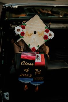 a graduate's cap sitting on the back of a car with flowers and ribbons