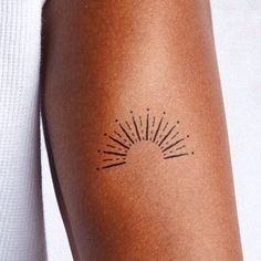 a woman's arm with sunburst tattoo on the back of her left arm