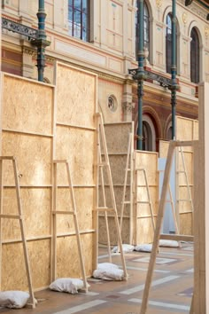 several wooden scaffoldings are lined up on the ground in front of a building