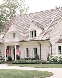 a large white house with an american flag on the front door and two story windows