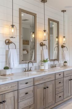 a bathroom with double sinks, mirrors and lights on the wall above them is shown