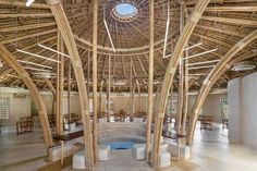 the inside of a building with wooden poles and benches on each side of the room