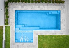 an aerial view of a swimming pool in the middle of a lawn and grass area