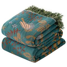 three blankets stacked on top of each other with pine needles sticking out of the middle