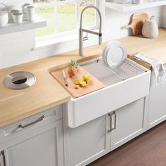 a kitchen sink with a cutting board on the counter