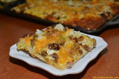 a slice of casserole sitting on a plate next to a pan of food