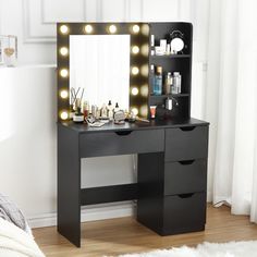 a black vanity with lights on it next to a bed