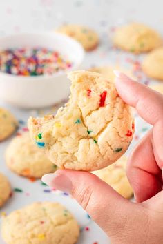 a hand holding a cookie with sprinkles