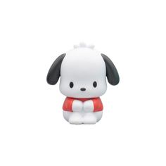 a white and black dog figurine sitting on top of a white floor next to a wall