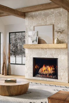 a living room with a fire place next to a window and a coffee table in front of it