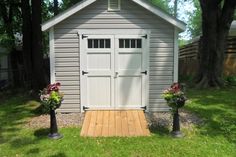 a small shed with two planters in front of it