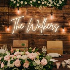 a wooden wall with the words the walkers on it and flowers in front of them