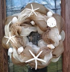 a wreath with seashells, starfish and a cross on it