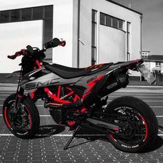 an orange and black motorcycle parked in front of a building