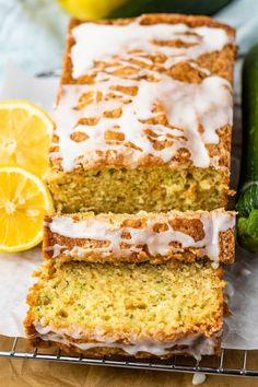 slices of lemon zucchini bread with icing on a cooling rack next to cucumbers