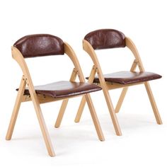 two wooden chairs with brown leather seats on each side and one chair facing the same direction