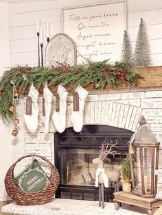 a fireplace decorated for christmas with stockings hanging from the mantel and wreaths on top