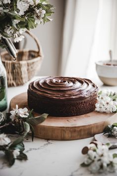 a chocolate cake sitting on top of a wooden cutting board