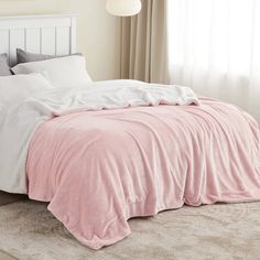 a bed with a pink comforter and white sheets