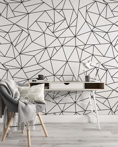 a chair and table in front of a geometric wallpaper