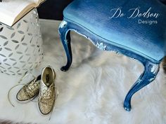 a pair of shoes sitting on top of a white rug next to a blue stool